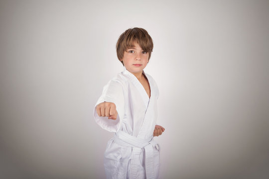 Karate kid wearing white kimono posing