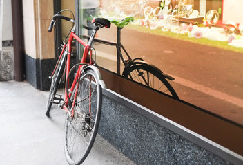Fototapeta na wymiar Bike leaning against shop window, downtown, europe environment -