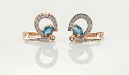 Gold earrings in the shape of a horseshoe adorned with Topaz stones