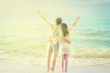 Vintage tone photo of Asian couple on beach with warm sun light