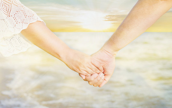 Asian Couple Is Holding Hand Near To The Sea With Warm Sun Light Sky