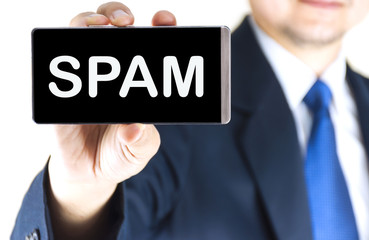 SPAM word on mobile phone screen in blurred young businessman hand over white background, business concept