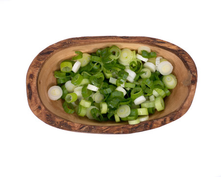 Organic green onion scallion in olive wood bowl on white background