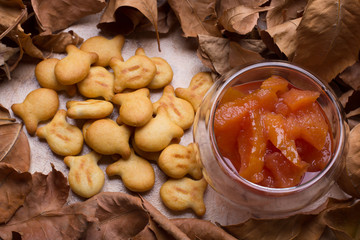 quince jam and small biscuits,  autumn leaves, glass bowl