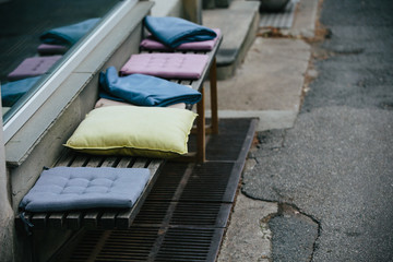 Street cafe. Europe. Cloudy weather is cold.
On the chairs are blankets and pillows.