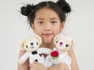 Lovely asian kid is playing wedding bear dolls