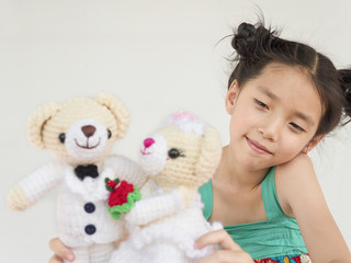 Lovely asian kid is playing wedding bear dolls