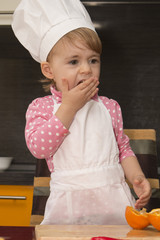 clouse-up portrait little cute girl in chef suit. Mother's helper. 2 year old.