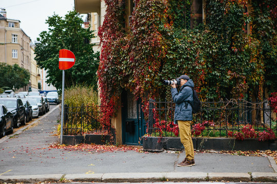 Male tourist photographing on city street