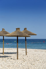 Parasols at the beach in front of blue ocean