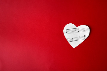 Paper heart with music notes on red background