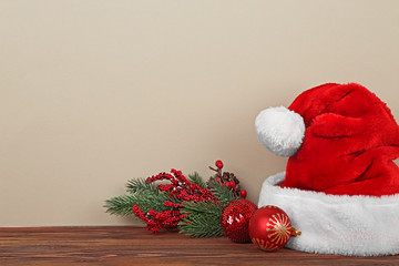 Obraz na płótnie Canvas Santa Claus hat with Christmas decoration on color background