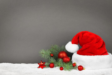 Obraz na płótnie Canvas Santa Claus hat with Christmas decoration on gray background