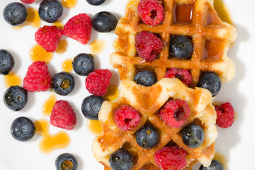 Close-up of waffles with berries and maple syrup