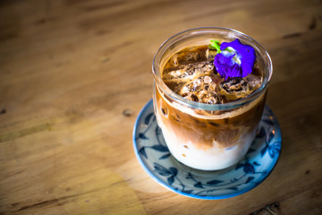 iced coffee With fresh milk on the bottom .Placed on a wooden table ready to serve you.