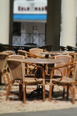 Street cafe with brown  tables and cane chairs. 
