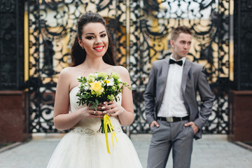 Bride with bouquet and groom on the background