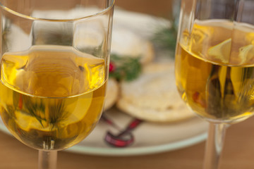 Two glasses of wine in front of christmas mince pies