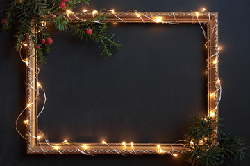 Frame with Christmas lights and decor on black with copyspace