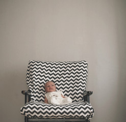 cute newborn baby sitting in the big chair