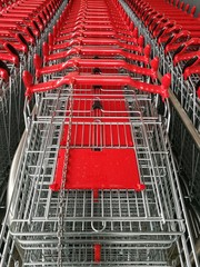 Ineinandergeschobene Einkaufswagen aus Drahtgeflecht mit rotem Kunststoff vor einem neueröffneten...