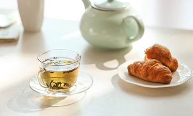 Cup of tea with croissants on table