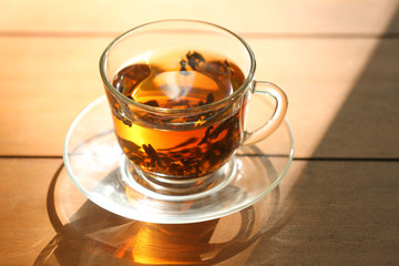 Glass cup of tea on wooden table