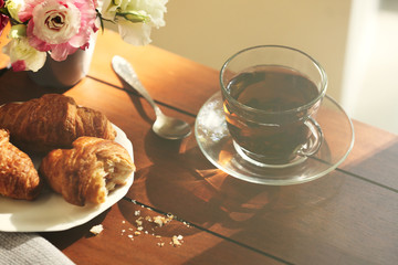 Cup of tea with croissants on table