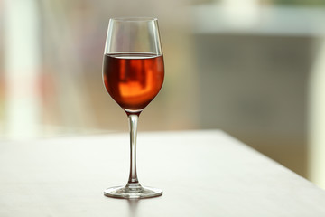 Glass with red wine on table