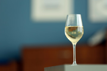 Glass with white wine on table