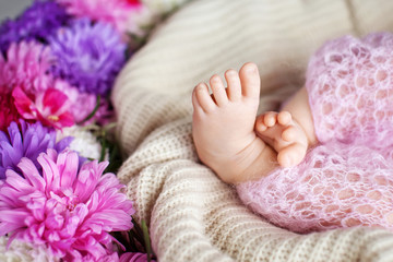 Close up picture of new born baby feet on knitted plaid