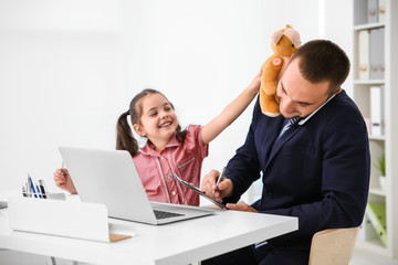 Daughter playing with father in office