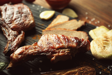 Grilled meat with vegetables on cutting board, closeup