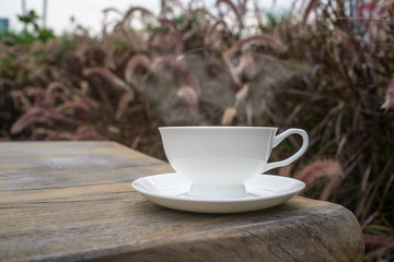 Coffee cup and tea On a Wooden table in the lawn garden.The visual style is warm Feeling relaxed