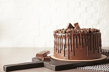 Tasty chocolate cake on brick wall background
