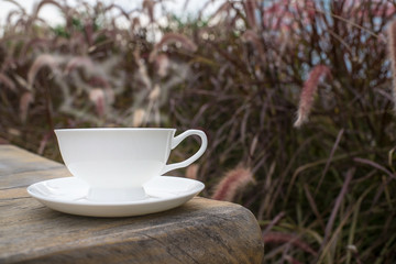 Coffee cup and tea On a Wooden table in the lawn garden.The visual style is warm Feeling relaxed