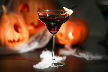 Close up view of tasty cocktail with decor for Halloween, on blurred background