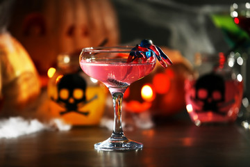 Close up view of tasty cocktail with decor for Halloween, on blurred background