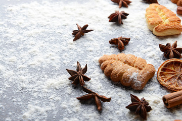 Composition of Christmas cookies, anise stars and flour on grey table