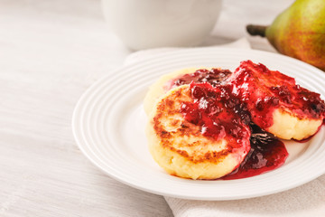 Cheesecakes with strawberry jam on a white plate