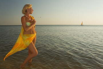 Beautiful woman in bikini and with pareo at the beach