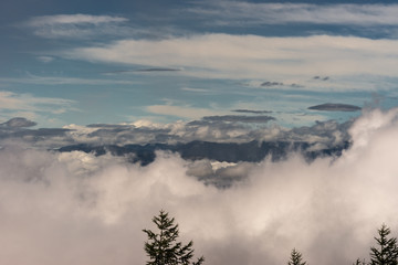 Hakone, Japan - September 27, 2016: Looking West from the slope of Mount Fuji offers different shapes and colors of clouds and sky with a dark mountain range at the horizon.
