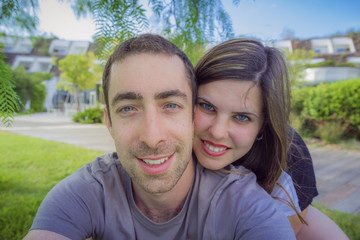 Fototapeta premium Happy couple taking selfie with smartphone or camera in the park