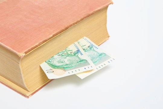 South African Rand in book isolated on white