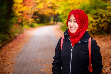 Muslim woman in North America during autumn with colorful maple leaf as background