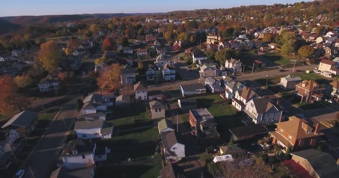 A slowly moving backwards aerial shot of a typical Western Pennsylvania neighborhood in the Autumn. Pittsburgh suburb.  	