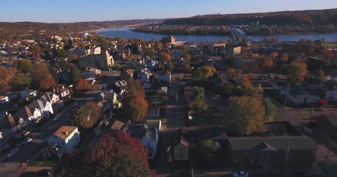 A slowly moving forward aerial shot of a typical Western Pennsylvania small town in the Autumn. Ohio River in distance. Pittsburgh suburb.	 	
