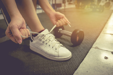 Closeup portrait of a woman hands tying shoelaces. vintage.