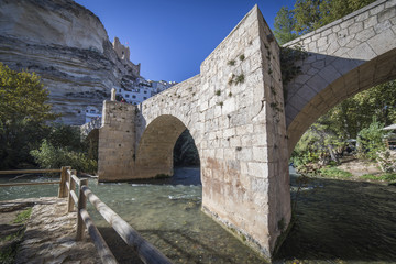 Fototapeta na wymiar Roman bridge, located in the central part of the town, Alcala del Jucar, Spain