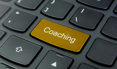 Business Concept: Close-up the Coaching button on the keyboard and have Gold, Yellow color button isolate black keyboard